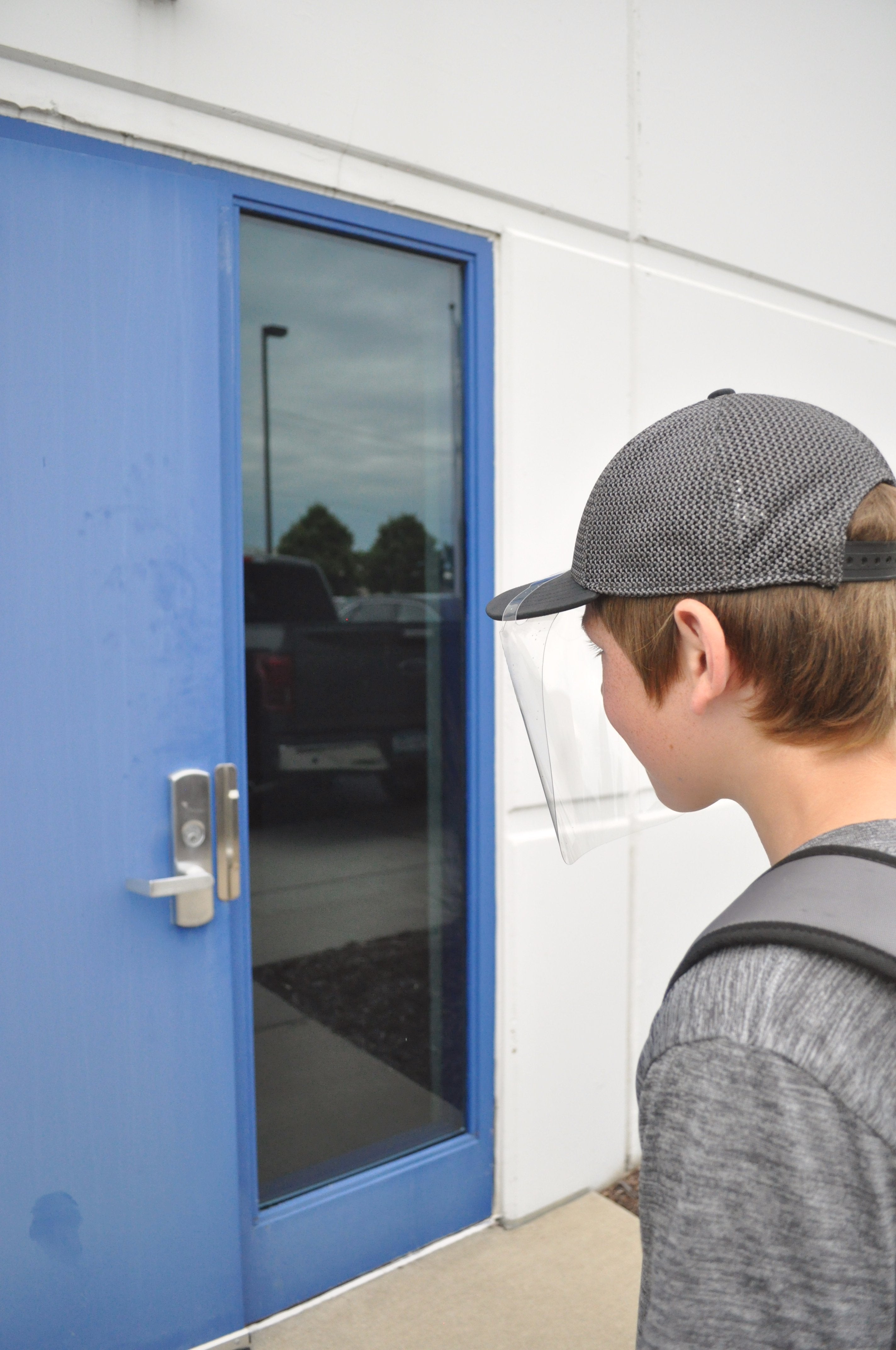 Boy walking towards a door while wearing a QuickShield