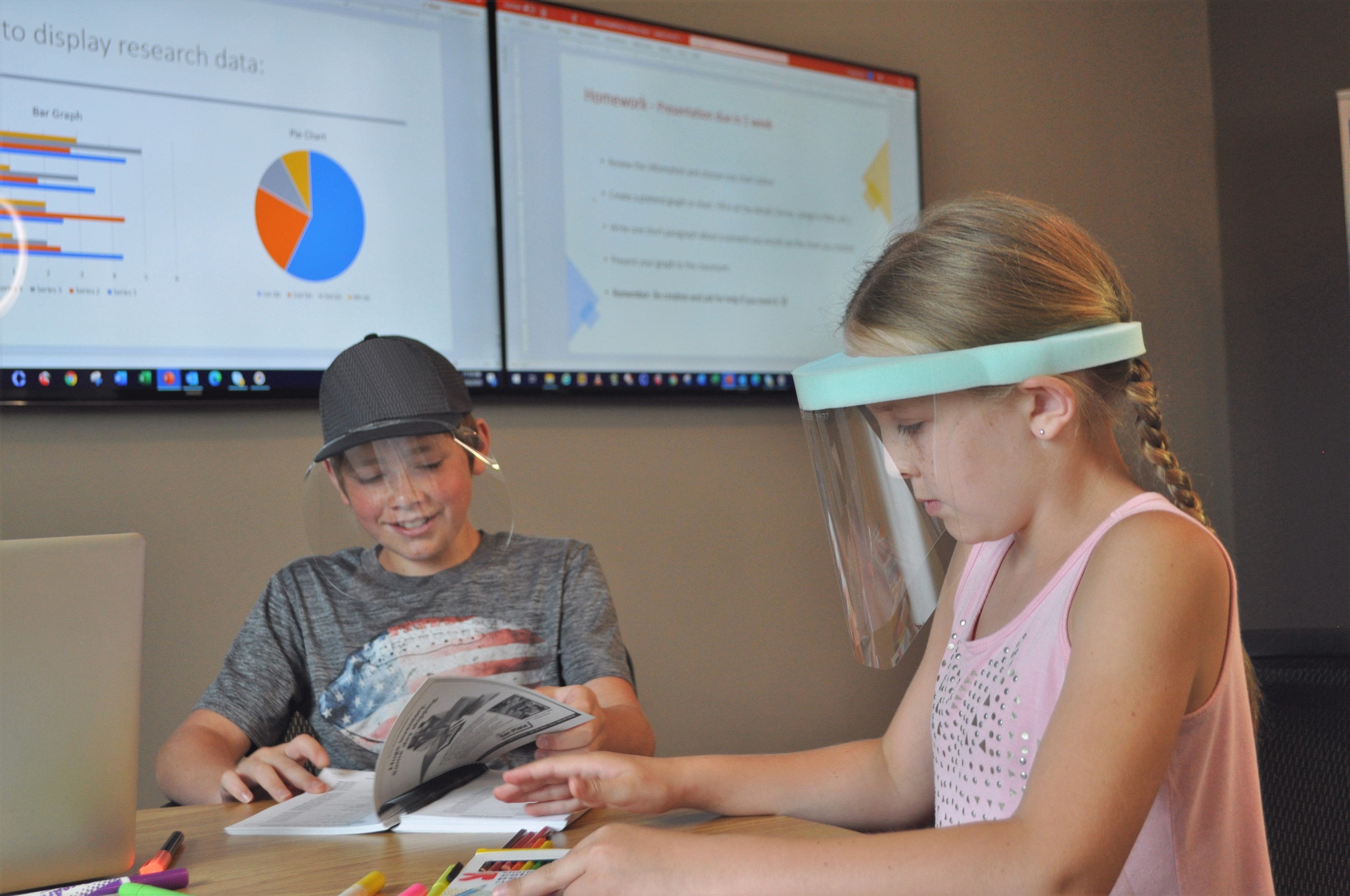 Boy wearing a QuickShield while reading with a girl wearing a ComfaShield